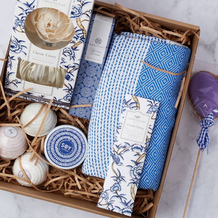 Close-up of the Decadence Delight Gift Set showcasing luxury items including a handwoven throw, soy candle, and Greenleaf products.