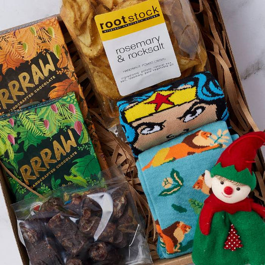 Elf's Delight Christmas Box featuring handcrafted chocolates, rosemary & rock salt crisps, Wonder Woman socks, and a festive elf ornament.