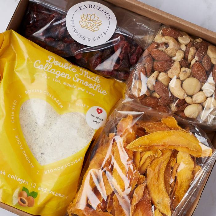 Close-up view of the Fabulous Wellness Delight Snack Gift Box with a focus on the collagen smoothie mix, dried mango, and nut medley.