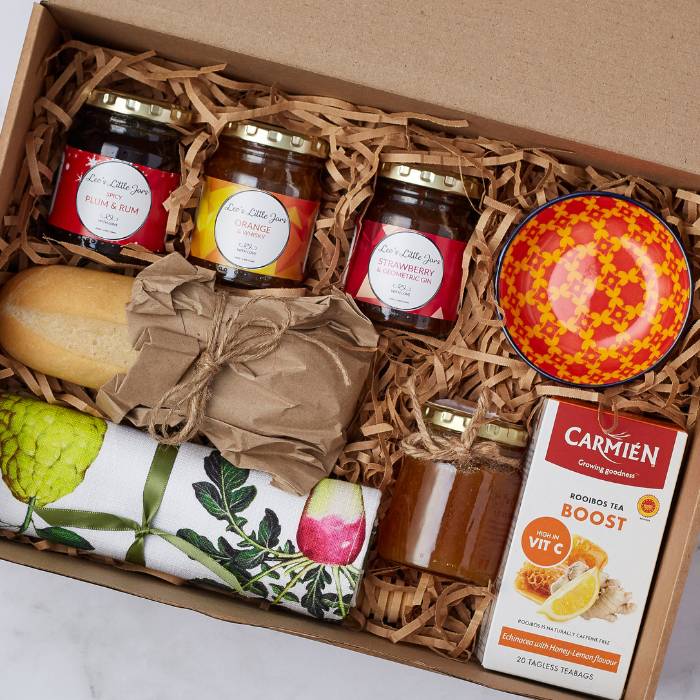 Close-up of Family Breakfast Gift Box contents: Lee’s Little Jars preserves, raw honey, bread loaf, and rooibos tea.