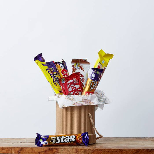 A beautifully arranged gift box featuring a variety of popular chocolate bars including Cadbury, KitKat, PS. Chocolate, and more from Flower Guy.