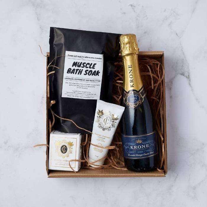 Krone & Calm Pamper Hamper Gift Box featuring Krone sparkling wine, muscle bath soak, scented candle, and luxury hand cream.