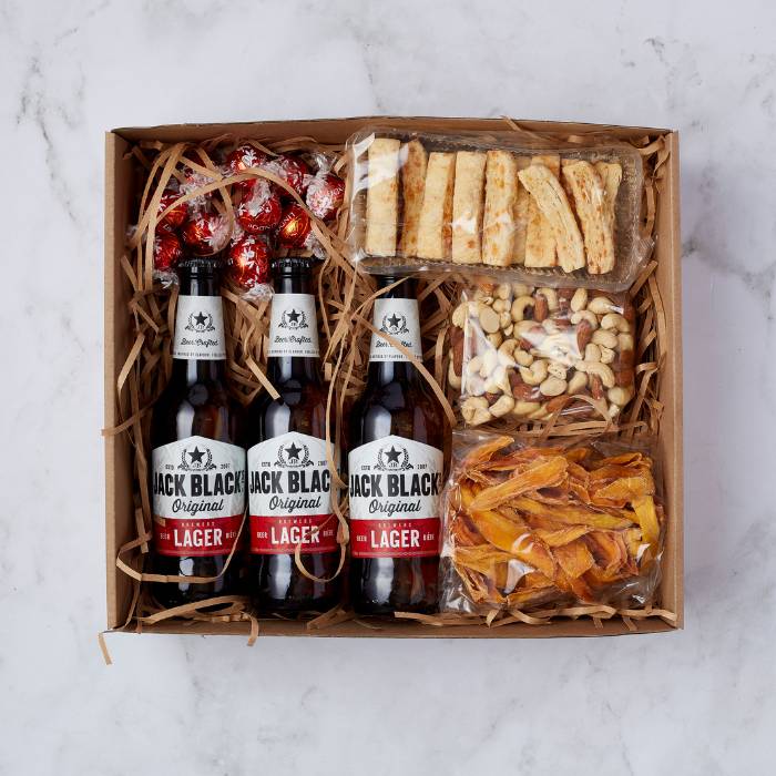 Lager & Snack Gift Box featuring Jack Black Lager, Lindt chocolates, cheese straws, nuts, and dried mango slices.