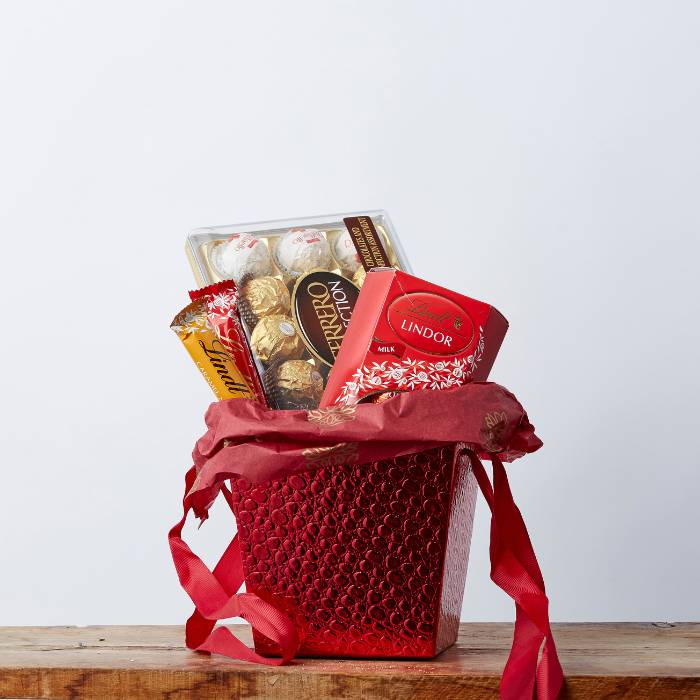 Lindt vs Ferrero Chocolate Hamper in a red gift basket with Lindt and Ferrero Rocher chocolates.