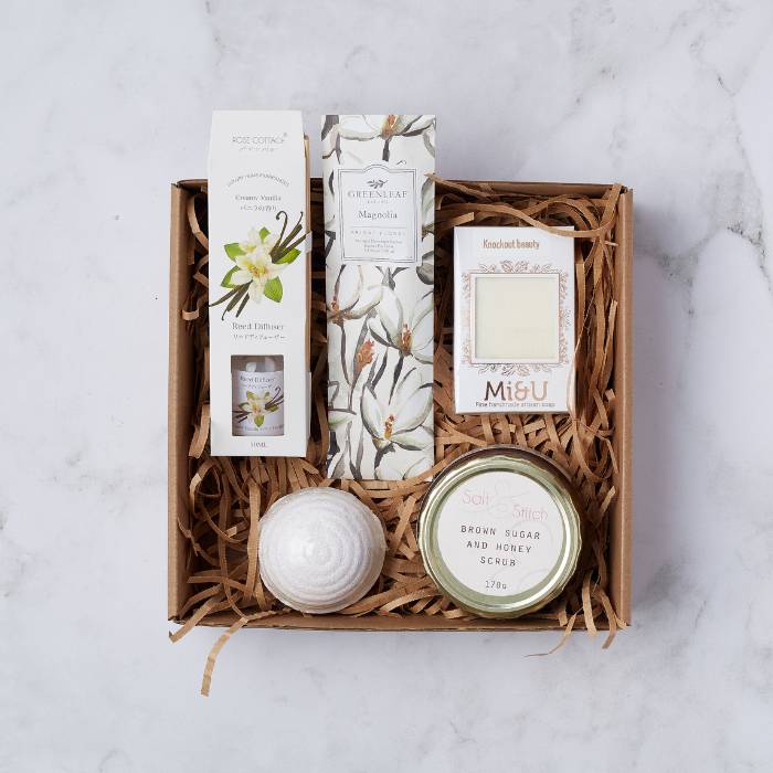 Magnolia Spa Gift Box with reed diffuser, handmade soap, magnolia sachet, scrub, and bath bomb.