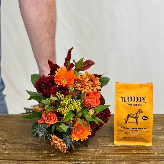 Flower Guy's chrysanthemum bouquet with Terbodore Dutch Chocolate Coffee being held by a man with gerberas and roses. 