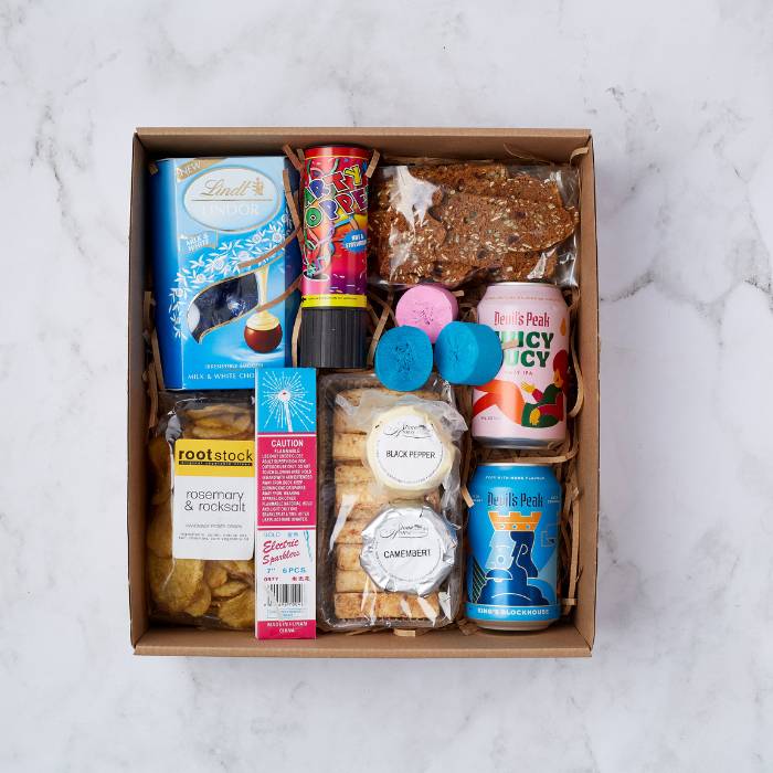 Party Spark Gift Box containing Lindt chocolates, Rootstock chips, Devil's Peak beers, bath bombs, and festive sparklers, beautifully packaged for celebrations.