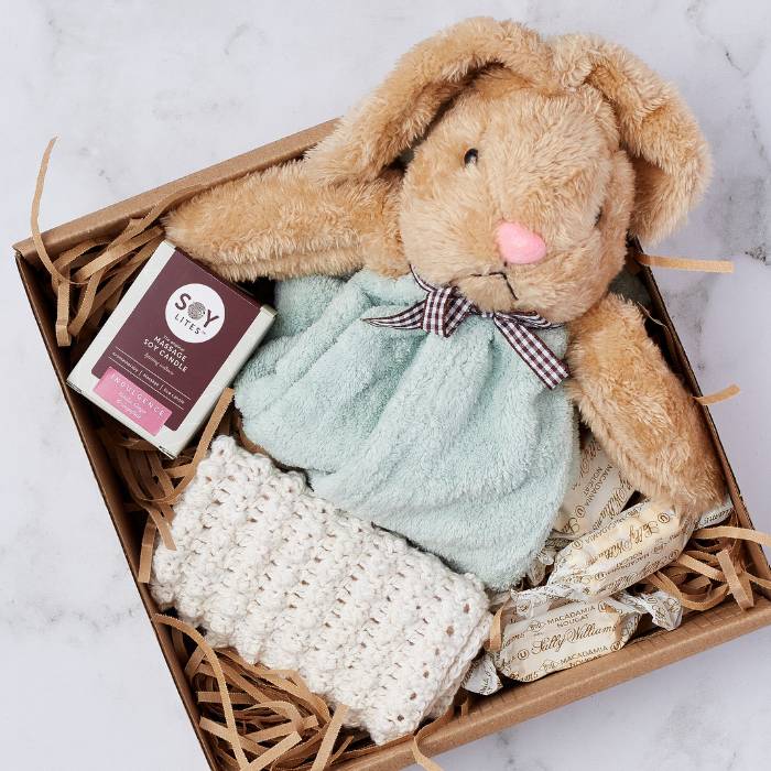 Close-up of Rabbit Dudu Gift Box with a soft rabbit comforter, candle, handmade blanket, and sweets arranged neatly.