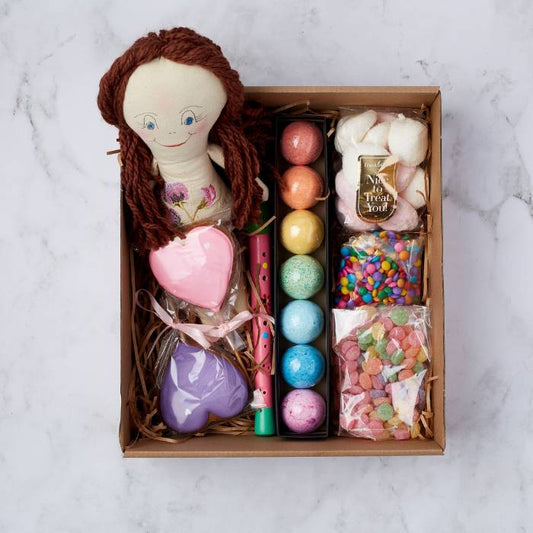 Rainbow Dreams gift box by Flower Guy featuring a handmade doll, heart-shaped cookies, bath bombs, and colourful sweets.