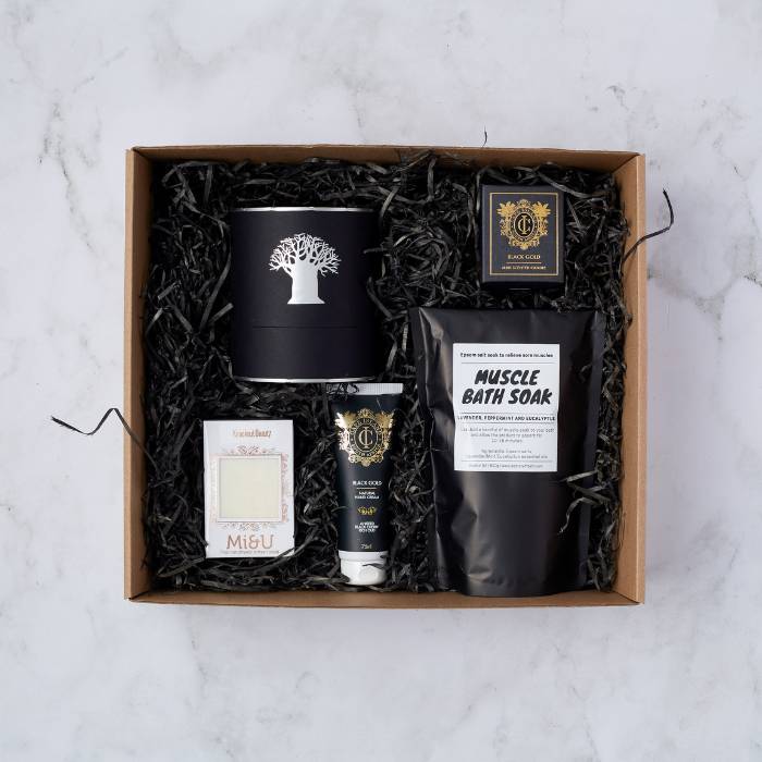 A beautifully curated Recharge Pamper Gift Box featuring bath soak, scented candles, hand cream, and artisan soap.