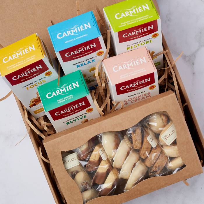 Close-up of Carmién tea packs and artisan biscuits arranged neatly inside the Regal TeaTime Delights Hamper.