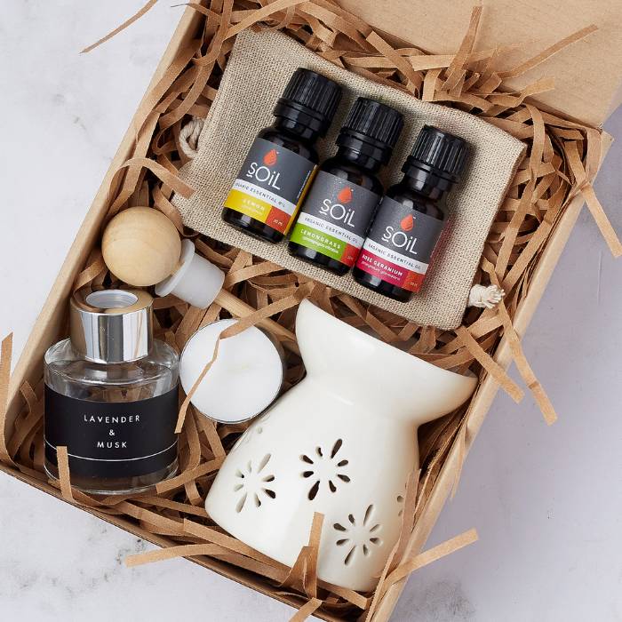 Beautifully presented Home Fragrance Essentials Set with a ceramic burner, lavender and musk diffuser, tealight candles, and three SOiL organic fragrance oils in a gift box.