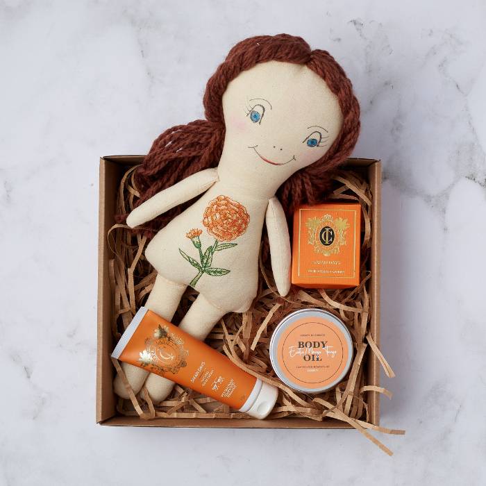 Safari Dreams Gift Box with handcrafted doll, body oil, candle, and hand cream displayed neatly in a brown gift box.