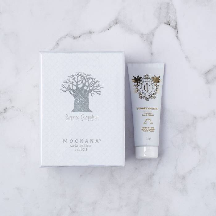 Mockana Sugared Grapefruit diffuser box with Cape Island Summer Vineyard hand cream on a marble background.