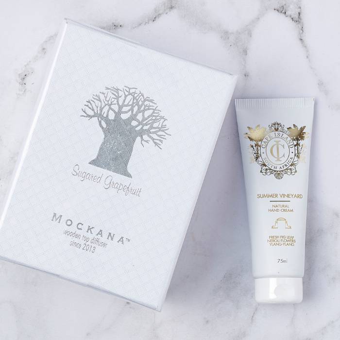 Close-up of Mockana Sugared Grapefruit diffuser and Cape Island Summer Vineyard hand cream in elegant packaging.