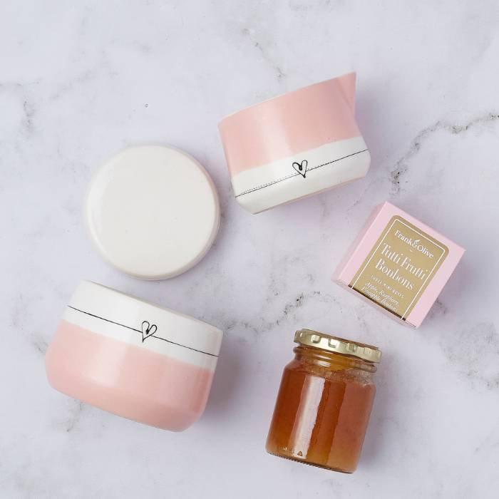 Close-up of the Sweetheart Gift Set showcasing a pink ceramic milk mug, sugar pot, tutti frutti bonbons, and a jar of artisanal jam, elegantly displayed.