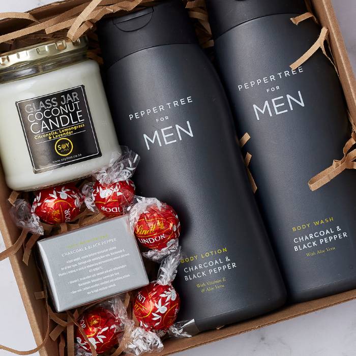 Close-up of The Gentleman’s Essentials Gift Box with Peppertree for Men grooming products, SoyLites candle, and chocolates.