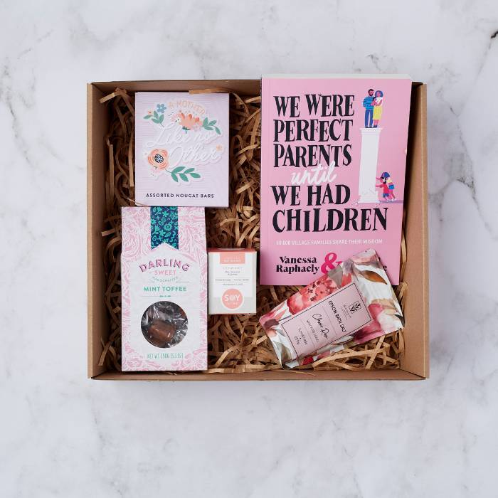 The Perfect Parent Pamper Gift Box featuring a book, nougat bars, mint toffee, soy candle, and rose bath soak.